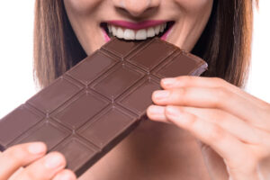 donna che mangia tavoletta di cioccolato fondente